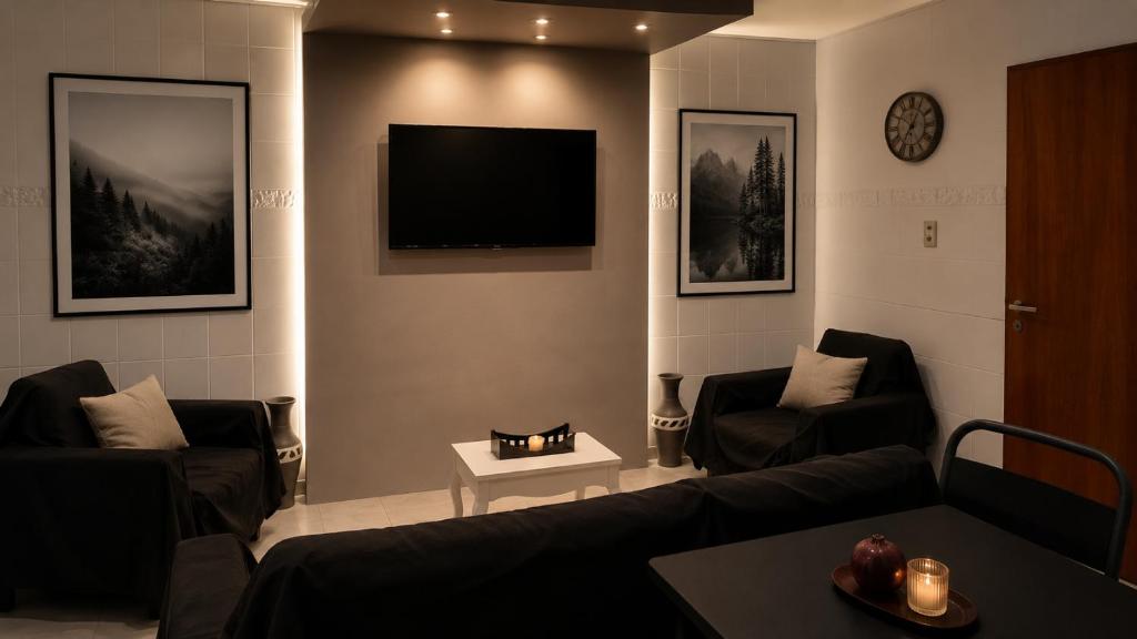a living room with two couches and a flat screen tv at Nova in Mendoza