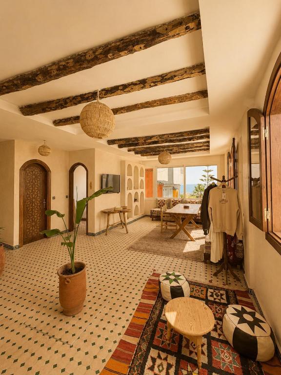 a living room with a table and a potted plant at Kymata Surf Morocco in Agadir
