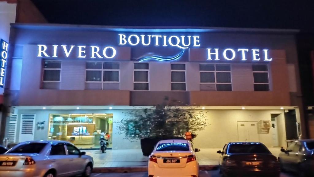 a hotel with cars parked in front of it at Rivero Boutique Hotel Melaka in Malacca