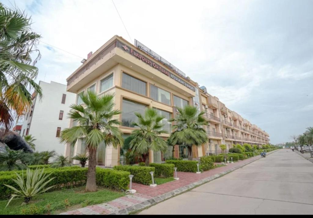 a building with palm trees in front of a street at krishna kunj stay in Mathura