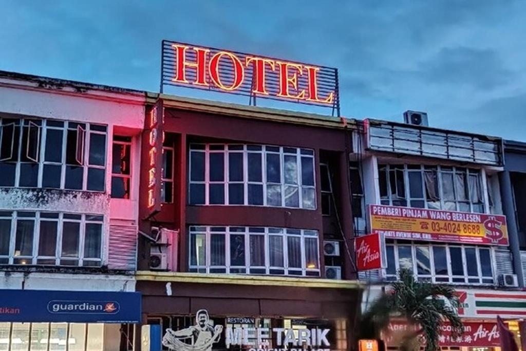 a hotel with a neon sign on top of it at Fast Hotel Idaman Near To IIUM KL in Kuala Lumpur