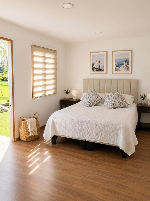 a bedroom with a large bed and a window at Alojamiento en Paine cerca Monticello in Hijuela Larga