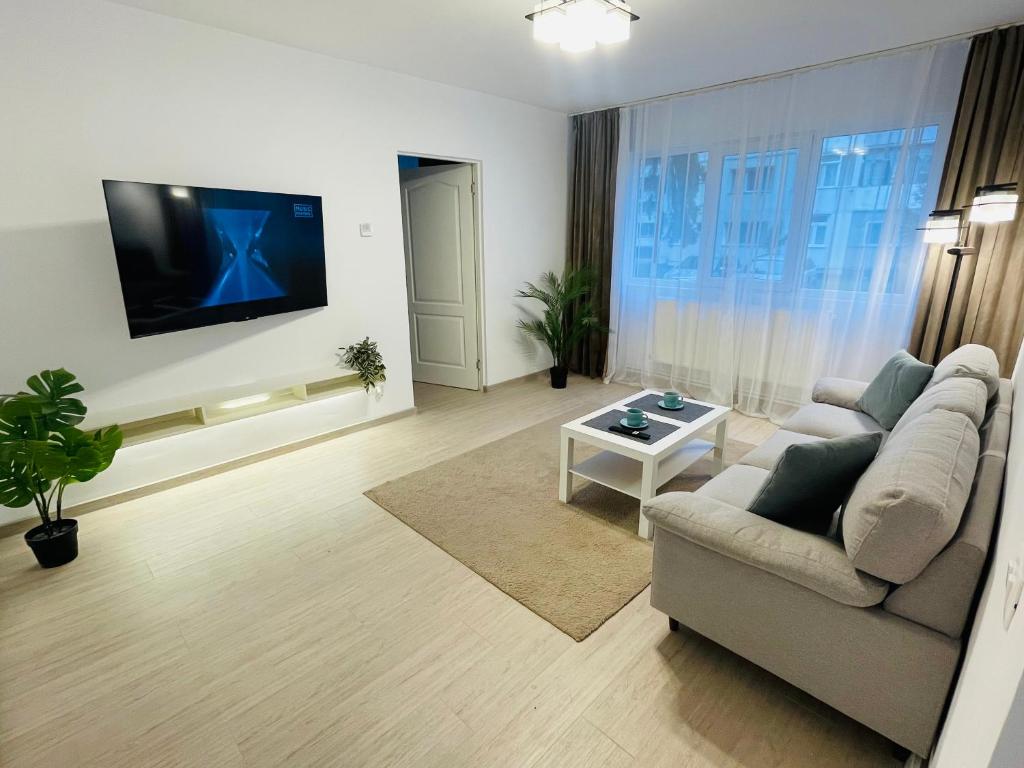 a living room with a couch and a flat screen tv at MBZ Apartments #1 - 1 Bedroom, Private Parking & Air Conditioning in Roman