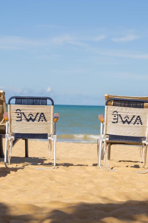 two beach chairs sitting on the sand at the beach at AWÊ Villa Boutique & Beach Club in Trancoso
