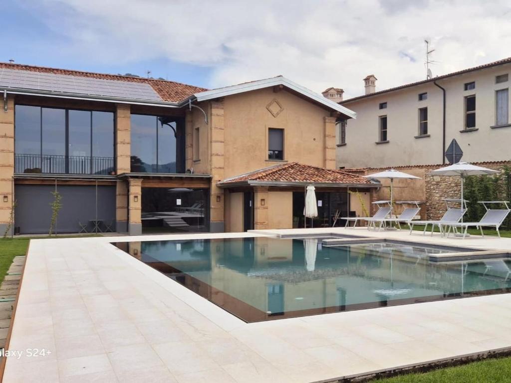 a swimming pool in front of a house at Elegant suite with porch and shared pool in Adro
