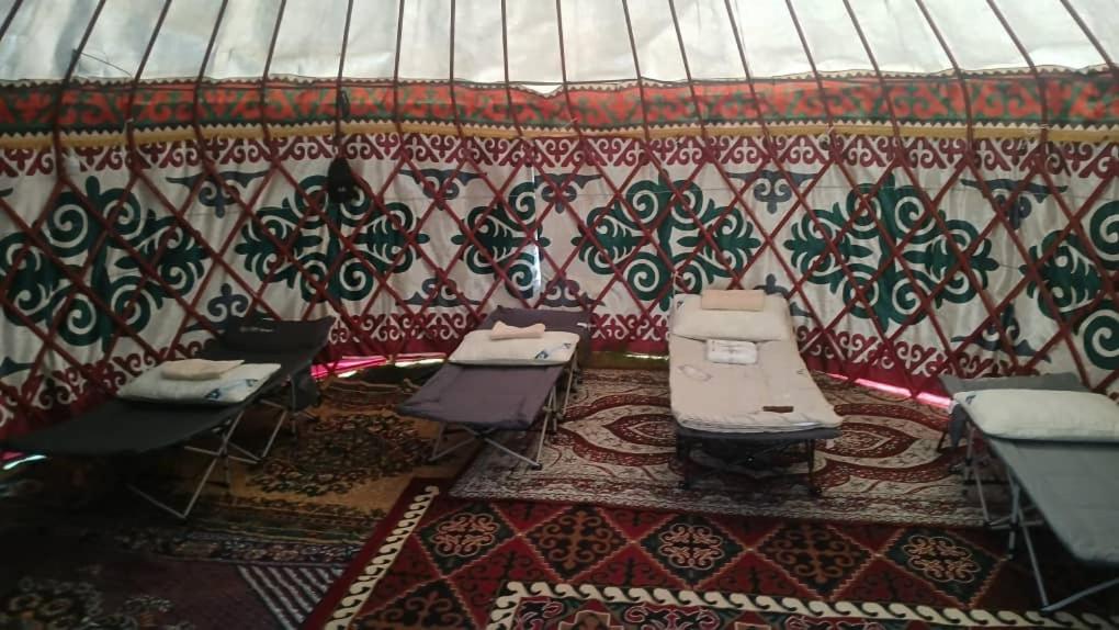 a room with chairs and tables and a wall at Актан in Chong-Kyzylsu