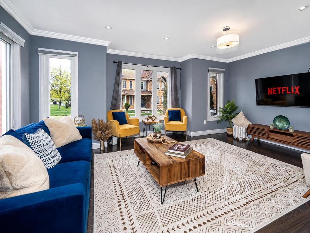 ein Wohnzimmer mit einem blauen Sofa und einem Tisch in der Unterkunft Spacious 3BDR Home Central Markham in Markham