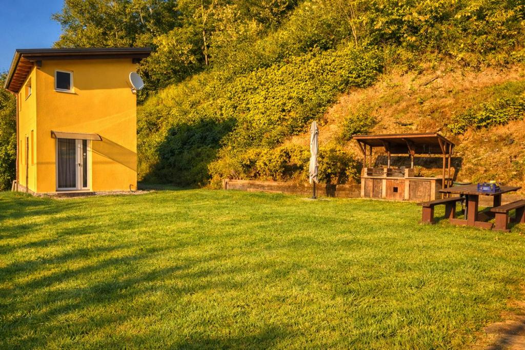 a yellow house on a hill with a picnic table at Nazem Holiday in Comunanza