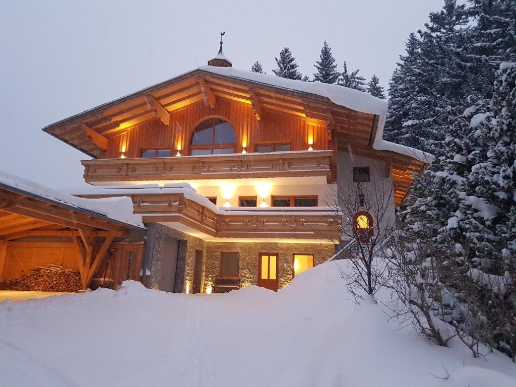 uma casa na neve com luzes acesas em Chalet Findeisen em Ramsau am Dachstein