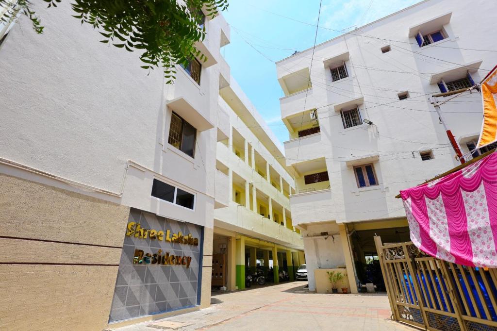 a building with a pink banner in front of it at Hotel Shree Laksha Residency Madurai in Madurai