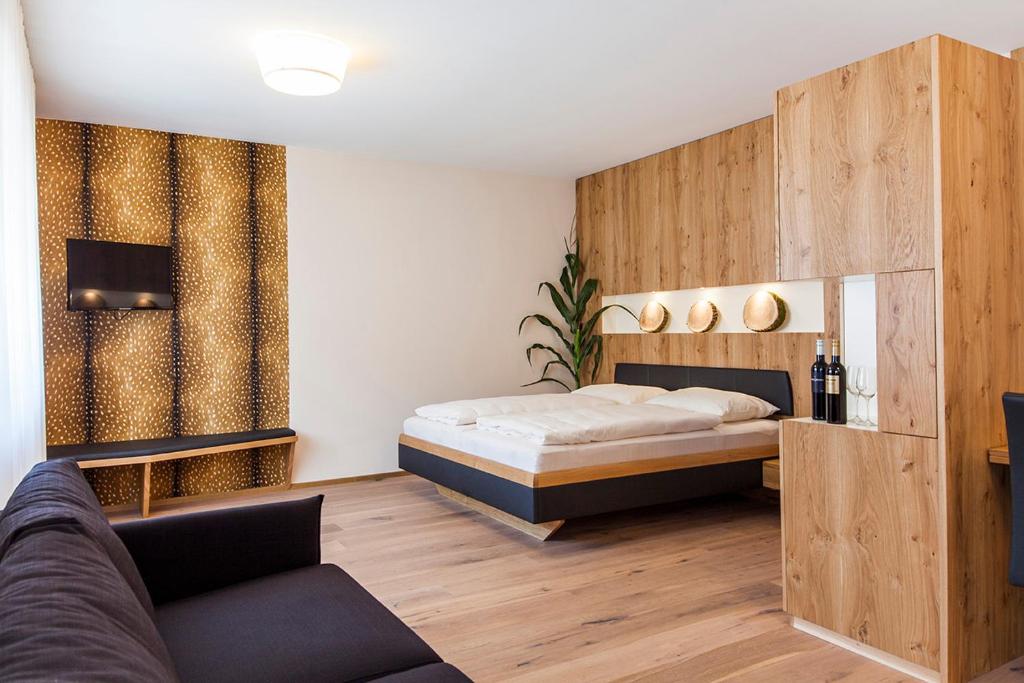1 dormitorio con 1 cama y 1 sofá en Weingut Gsellmann - Wohnen bei Ilse, en Gols