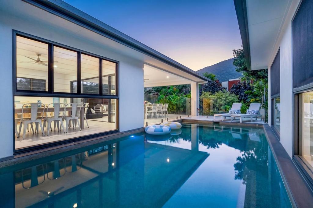 a swimming pool in a house with a house at Belle Escapes Sandcastles in Palm Cove