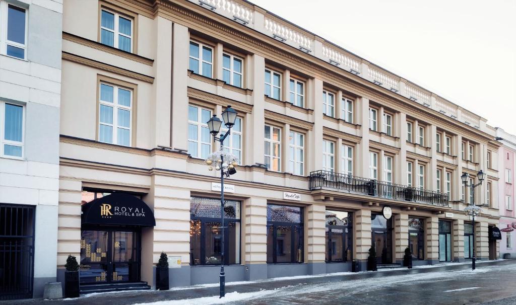 a large building on a street with a store at Hotel Royal & Spa in Białystok