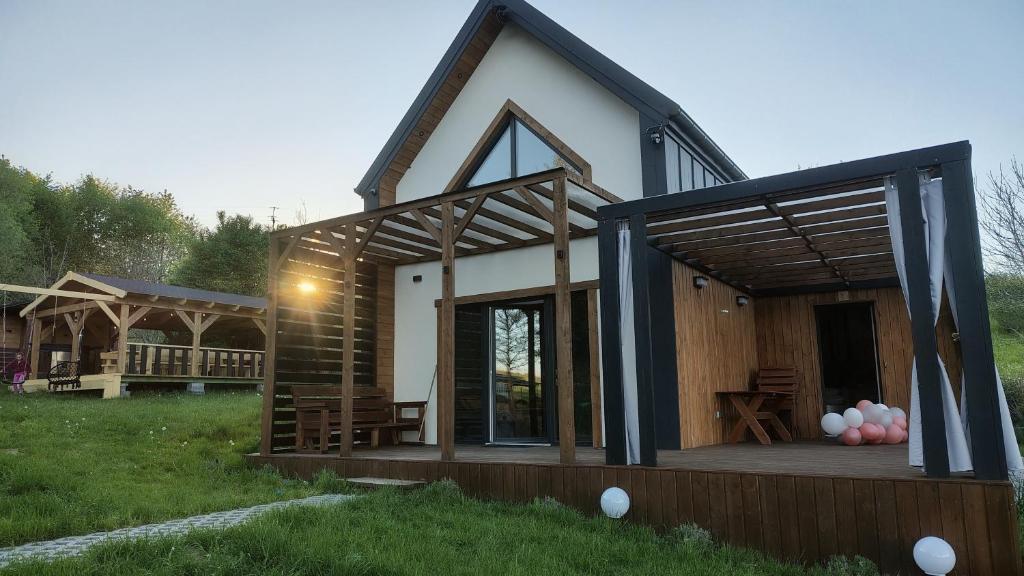 a small house with a porch and a deck at LoftLove roztocze domek in Jędrzejówka