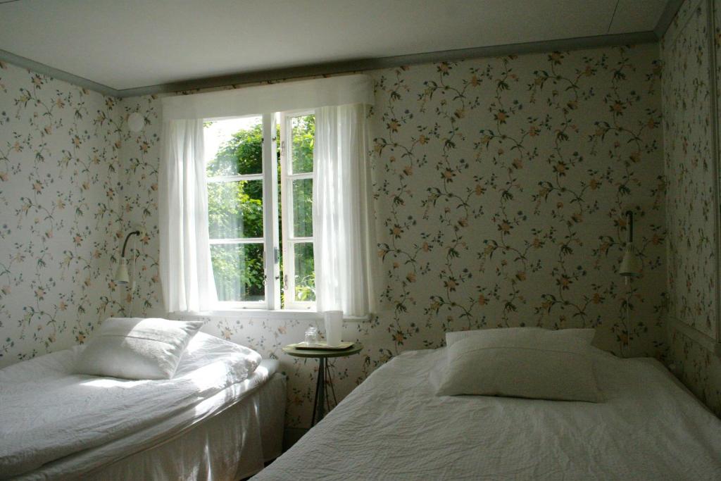 1 dormitorio con 2 camas y ventana en Uddens Bed & Breakfast, en Öregrund