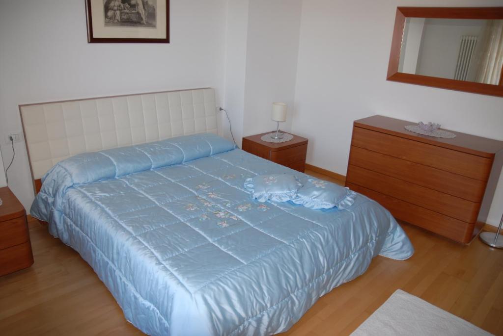 a bedroom with a blue bed and two dressers at Love & Live Pinè in Baselga di Pinè