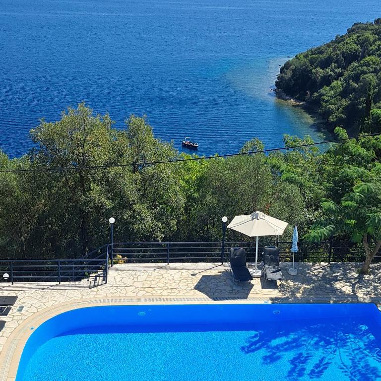 a swimming pool with a view of the ocean at Kerasia Villas - 4 apartments & cottage in (( Kerasá ))