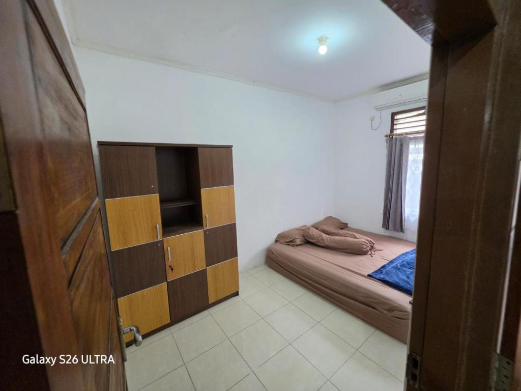a small bedroom with a bed and a television at Omah Diaz Homestay Malioboro in Jetis
