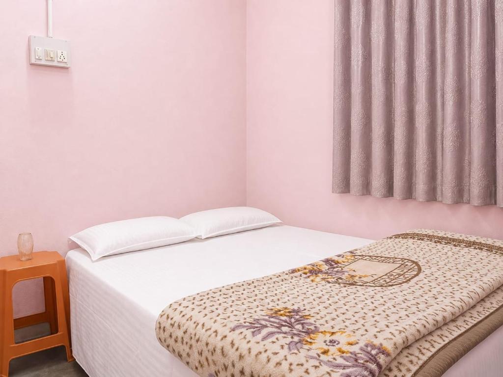 a small bedroom with a bed and a window at santosh lodge in Muzaffarpur