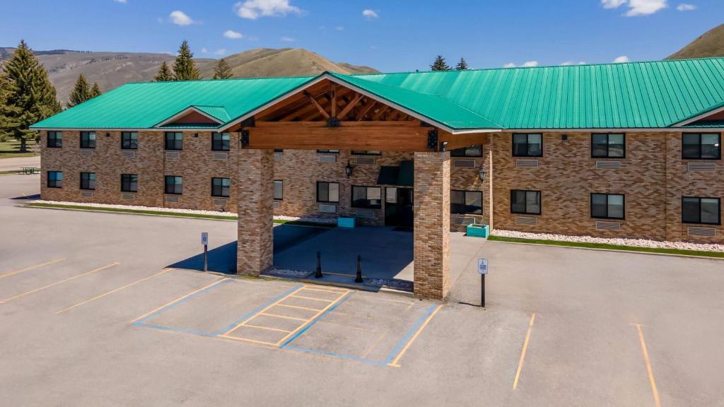 a large brick building with a green roof at Super 8 by Wyndham Montpelier - Bear Lake in Montpelier