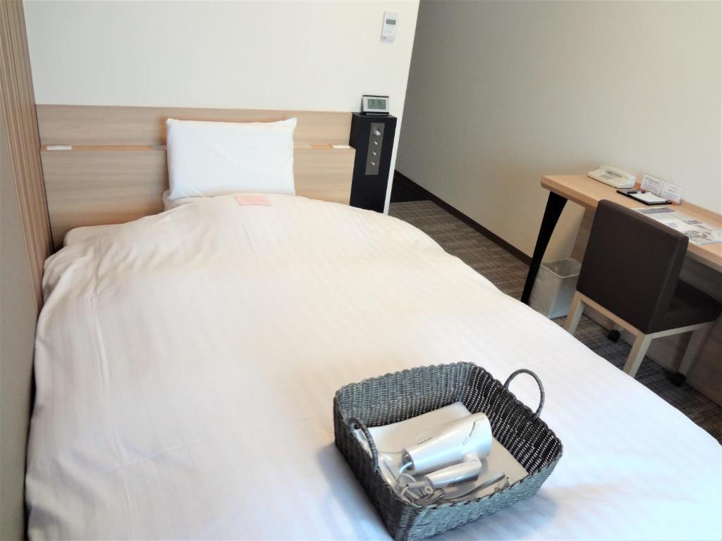 Postel nebo postele na pokoji v ubytování Toyama Chitetsu Hotel