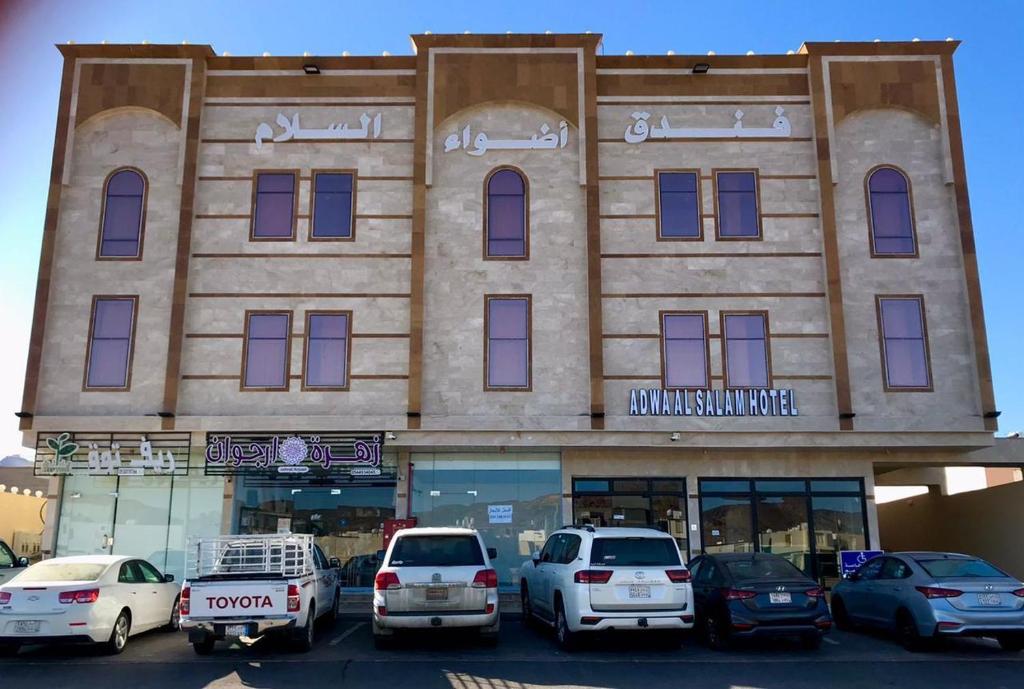 a building with cars parked in front of it at اضواء السلام للشقق المخدومة in Medina