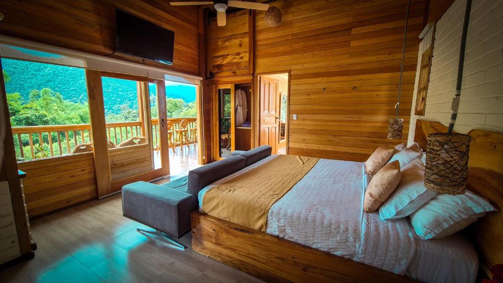 a bedroom with a bed in a room with a balcony at LA RUSTICA MiNDO in Mindo
