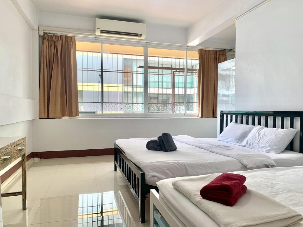 a bedroom with two beds and a window at We Hostel in Hat Yai