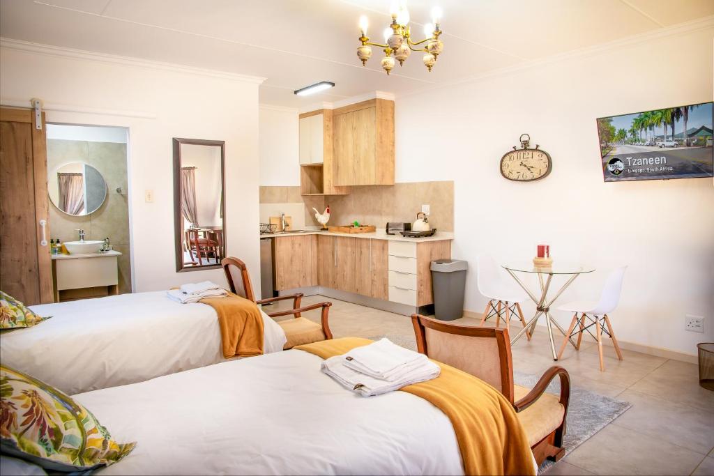 a room with two beds and a kitchen at Jac-Marie guests accommodation in Tzaneen