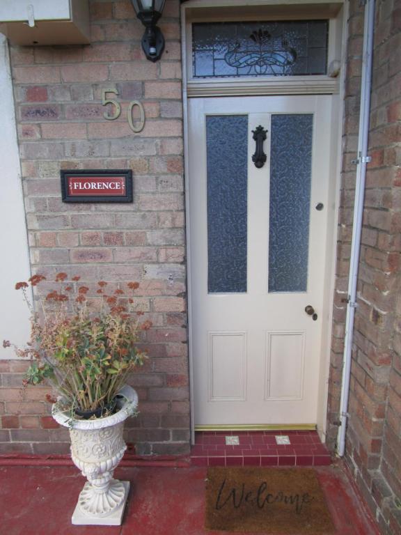 a front door of a house with a vase with a plant at Comfortable Victorian Terrace close to shops in Lithgow