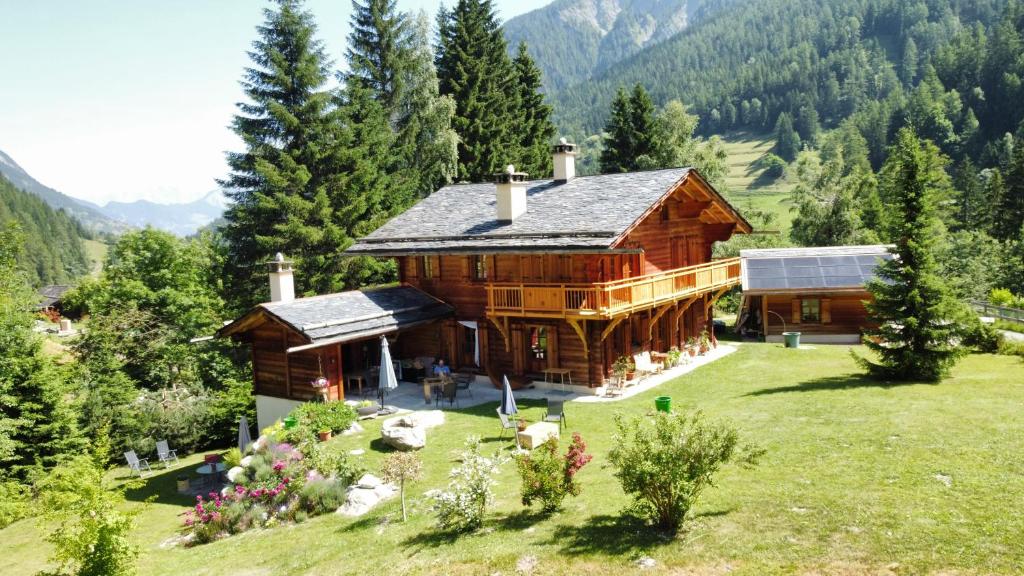 ein großes Holzhaus auf einem Hügel mit Bäumen in der Unterkunft Chez Pierre in Praz-de-Fort
