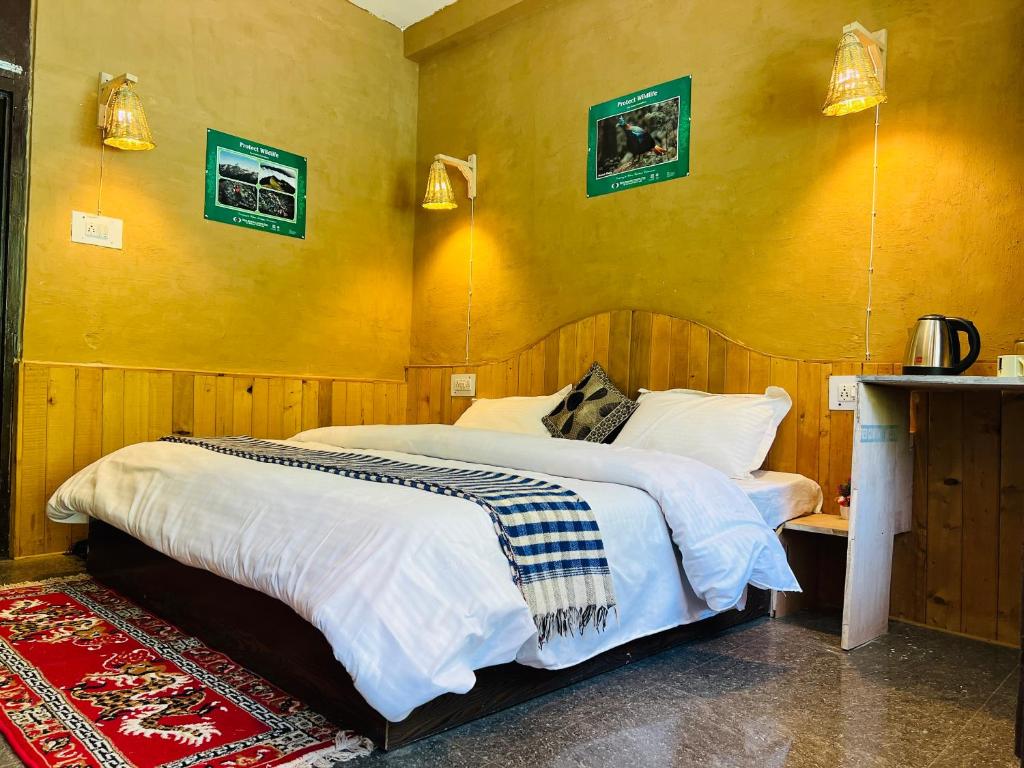 a bedroom with a bed and a yellow wall at Pond & Stone Homestay in Banjār