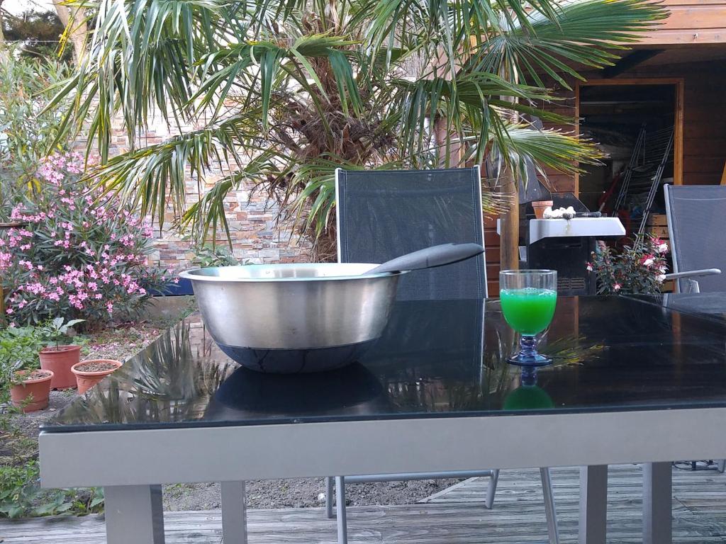 a bowl on top of a table with a glass at Maison Provost in Le Croisic