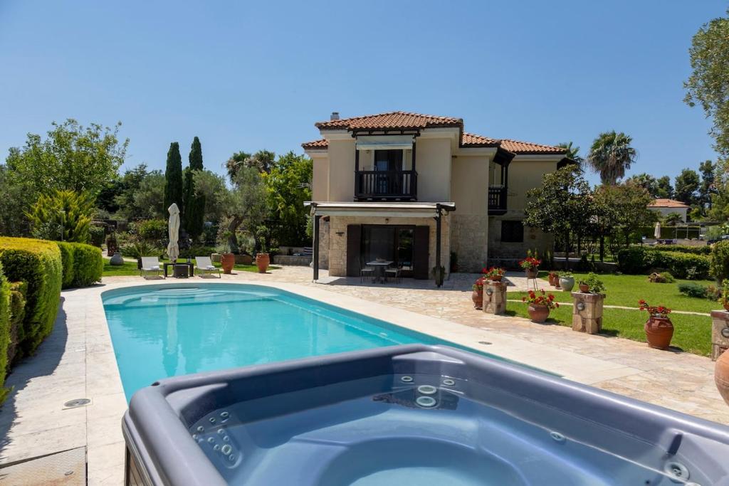 a swimming pool in front of a house at Eco Stone Villa with Private Pool and Jacuzzi in Kalandra