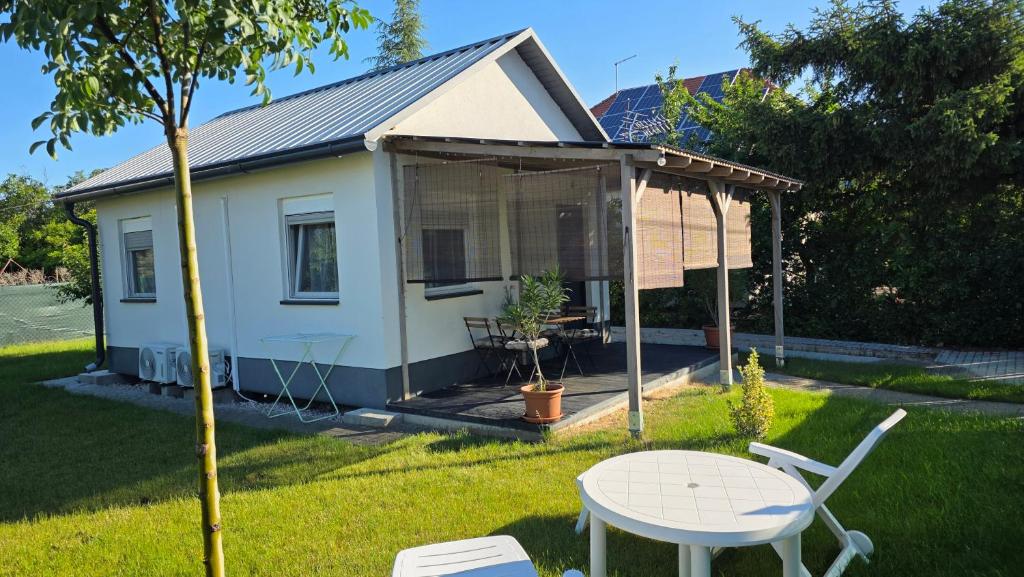 a tiny house in a yard with a table at Budatava Vendégház in Balatonalmádi