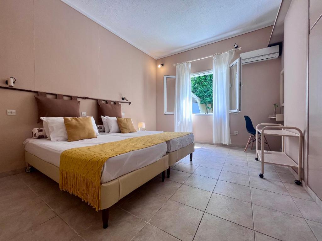 a bedroom with a large bed and a window at Korina's Apartments in Ipsos