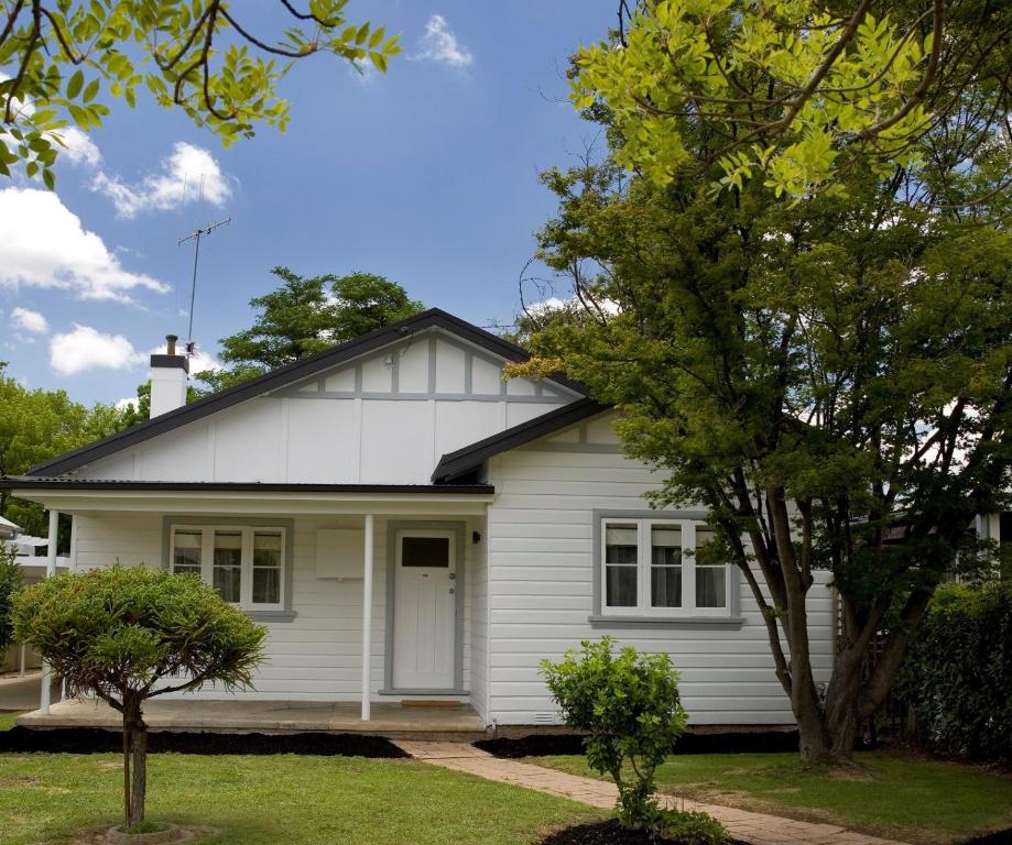 a white house with a tree in front of it at The Sampson - Orange in Orange