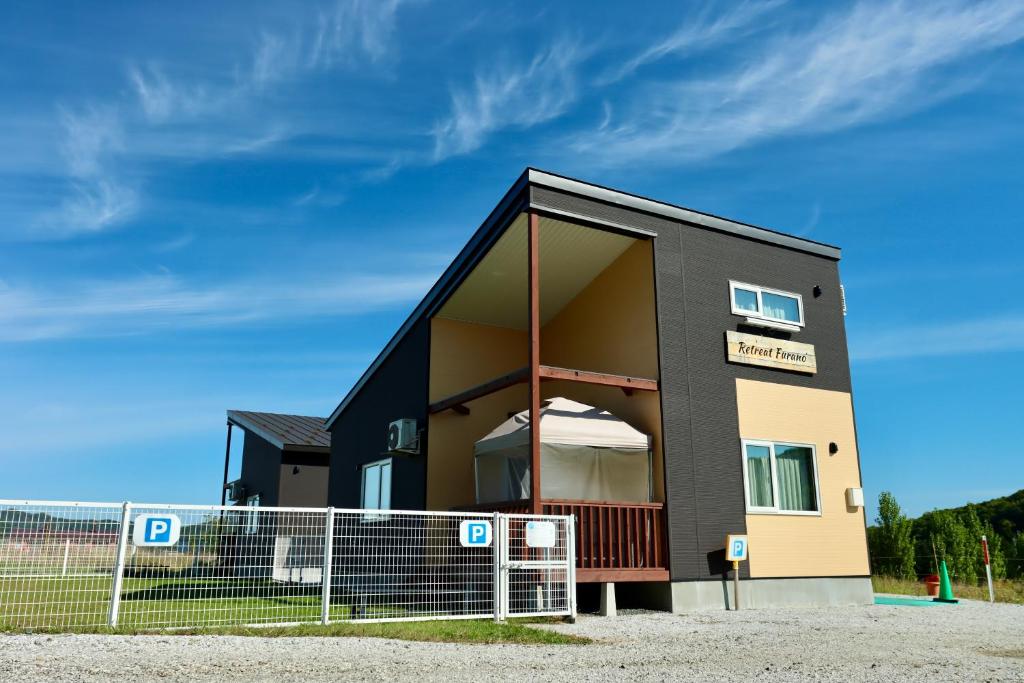 a building with a fence in front of it at Retreat Furano A in Furano