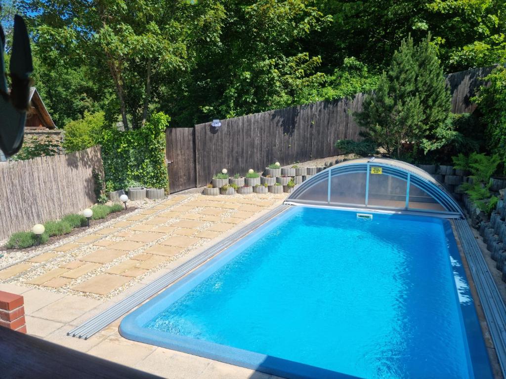 a swimming pool in a backyard with a fence at Ferienzimmer Kefeder in Lochenhaus