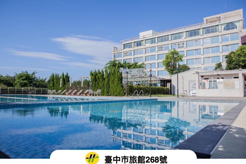 a large swimming pool in front of a building at Freshfields Hotel in Wuri