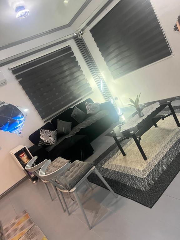 a living room with a couch and a table and a chair at Heart of Pasig in Manila