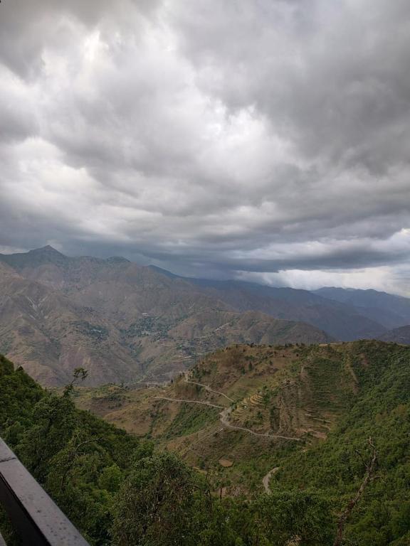 a view of a mountain valley under a cloudy sky at Sai Homestay in Mussoorie