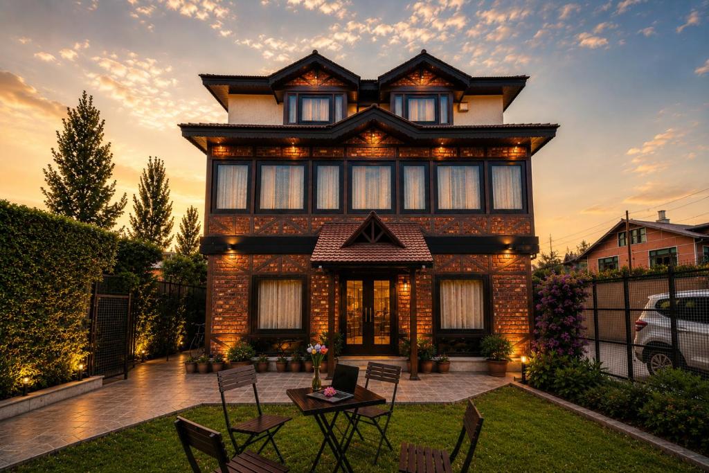 a house with a table and chairs in the yard at The Riverside Barn Srinagar in Srinagar