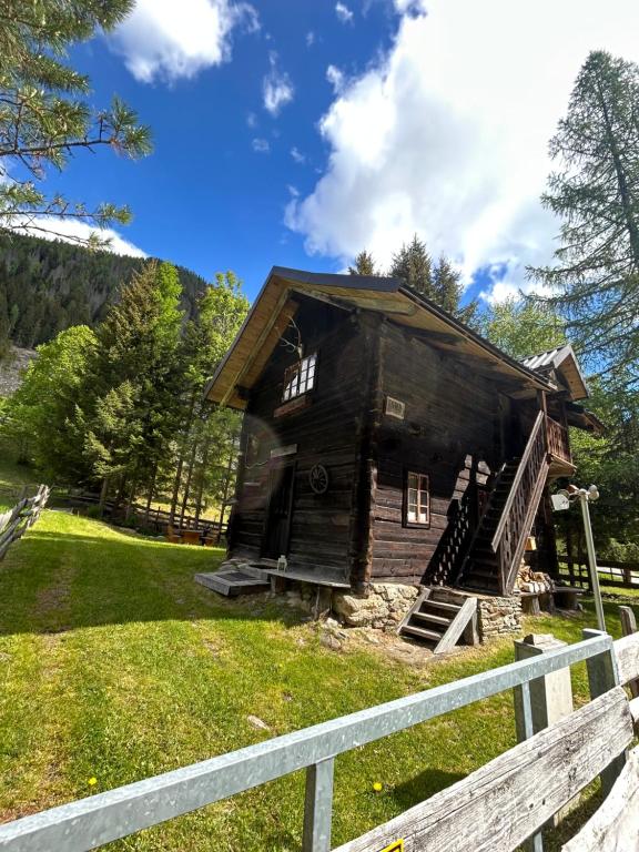 a log cabin in a field with a fence at HeinrichH in Teuchl