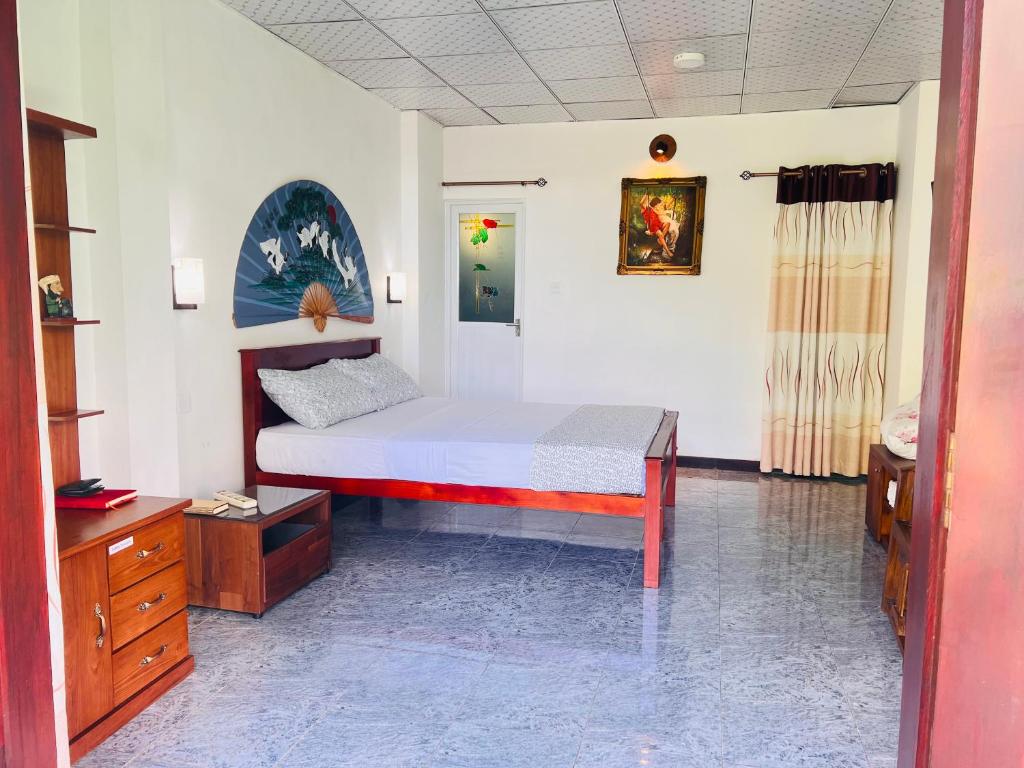 a bedroom with a bed and a dresser in it at Greenery Garden in Idamegama