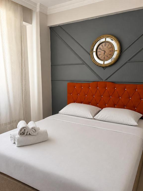 a bed with towels and a clock on the wall at Bolu novara suit in Bolu