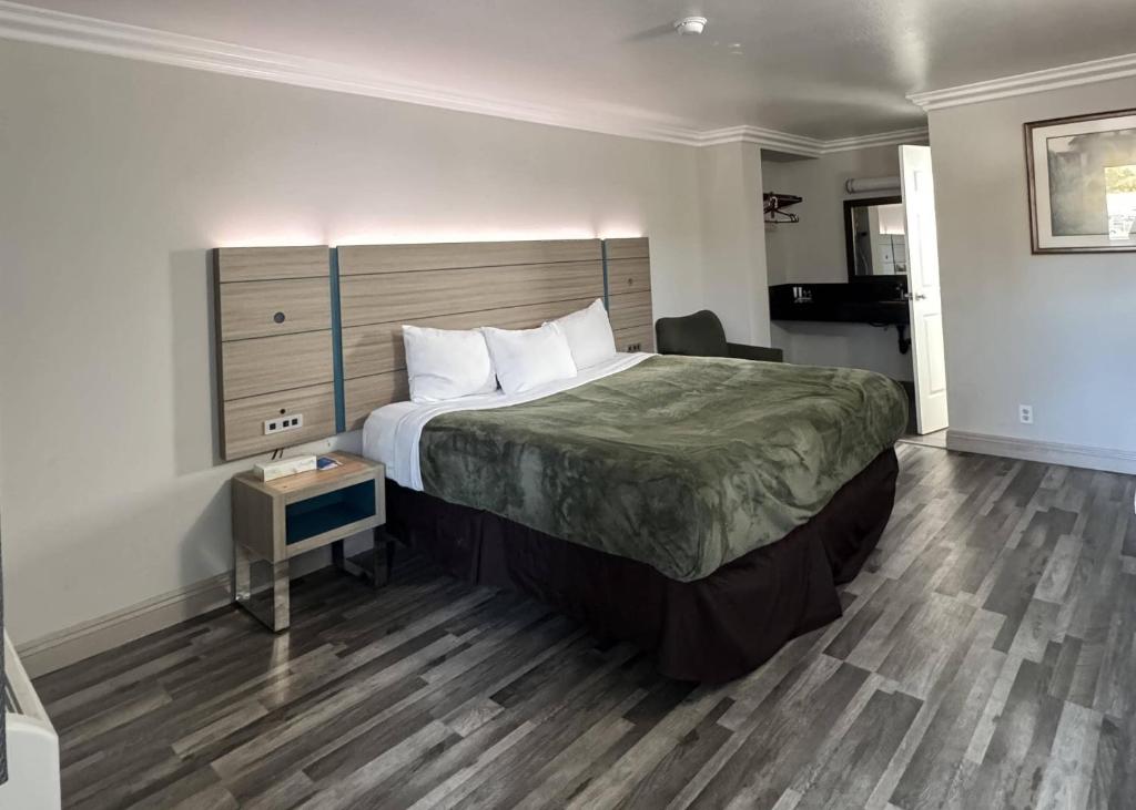 a hotel room with a large bed and a table at Rodeway Inn Ventura Midtown in Ventura