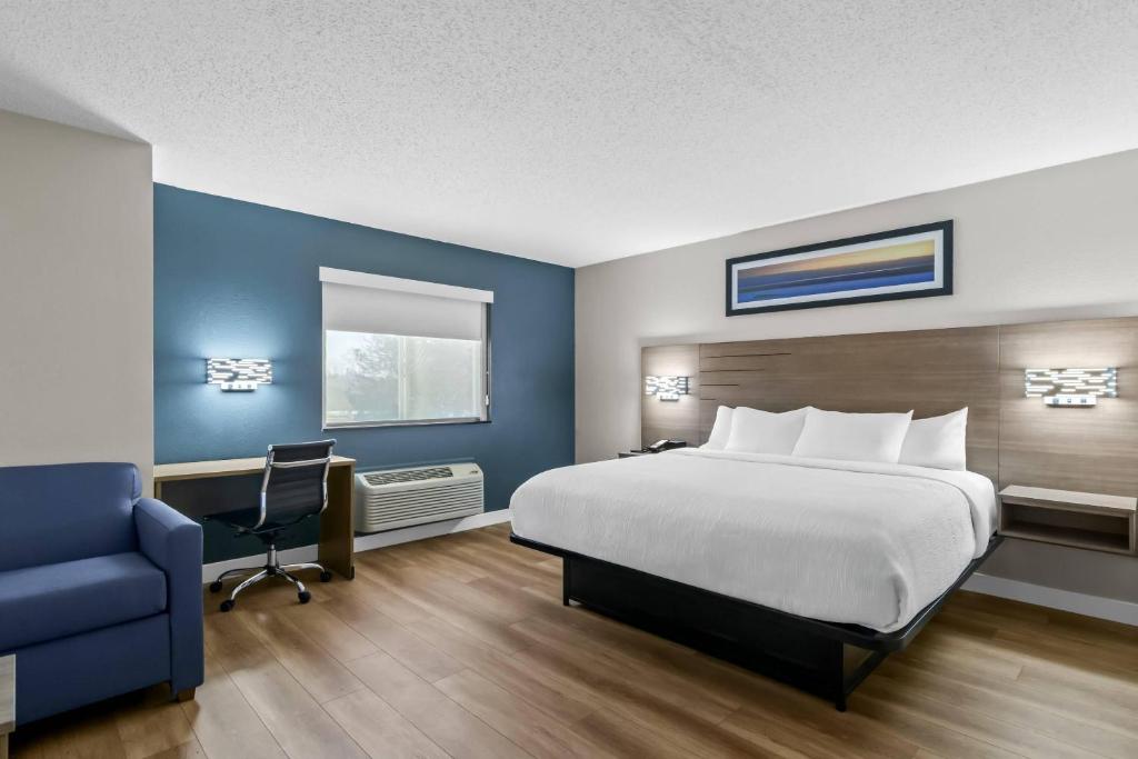 a hotel room with a bed and a desk and a chair at Quality Inn Neosho in Neosho