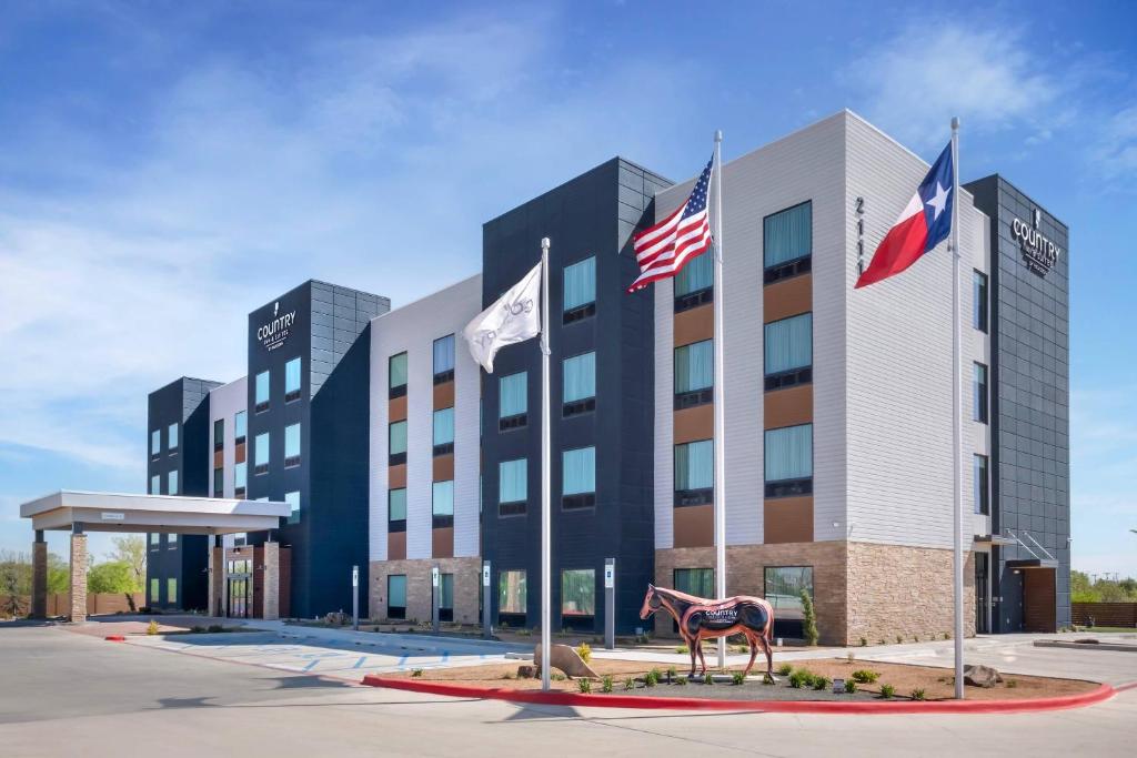 a hotel with flags in front of a building at Country Inn & Suites by Radisson, Amarillo Central in Amarillo