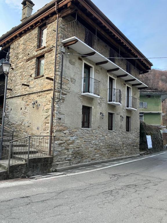an old stone building on the side of a street at Little Chariot in Monastero di Lanzo